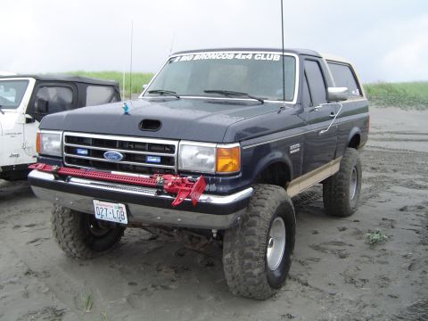 1989 Ford Bronco - This 1989 Ford Bronco, sporting off-road tires and a Hi-Lift jack, is part of the "BIG BRONCOS 4x4 CLUB" and is seen on the beach next to a…