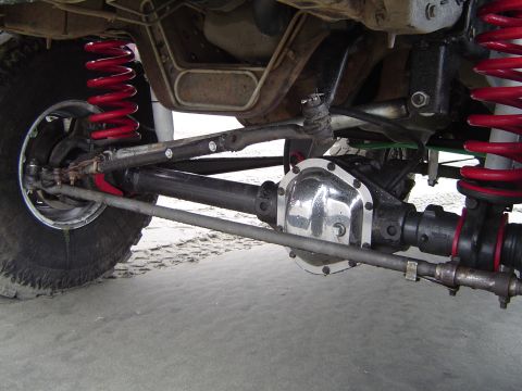 1989 Ford Bronco - Close-up view of the suspension and drivetrain components, red coil springs and a shiny differential cover.