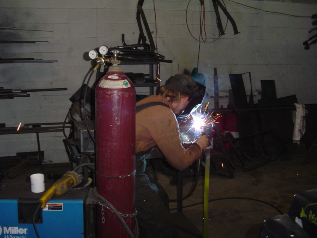 Welder sparks fly as a person works on metal with a welding torch