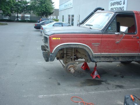 1983 Ford Bronco - 1983 Ford Bronco undergoing front end work, jacked up with wheel removed.
