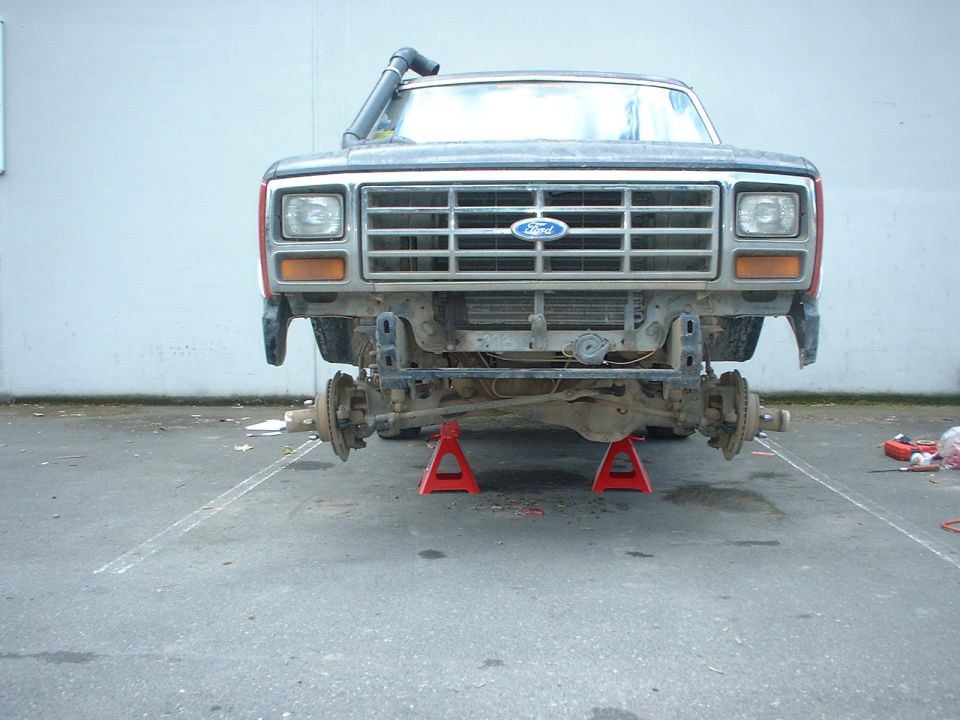 Ford truck front end on jack stands, missing bumper and fenders, snorkel visible