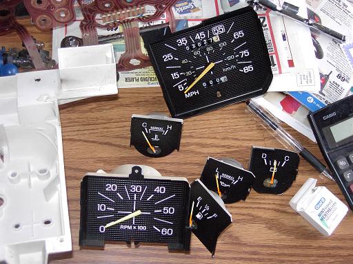 Disassembled Ford truck gauge cluster with speedometer, tach and small gauges