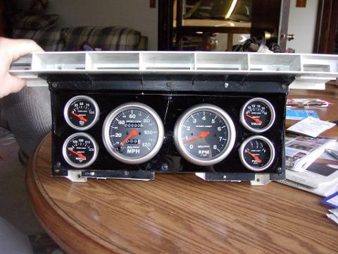 1980 Ford Bronco - A collection of automotive gauges, including a speedometer and tachometer, are displayed on a black panel.