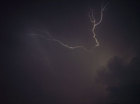 1990 Ford Bronco - A dramatic lightning strike illuminates the dark, stormy sky, with the Supermotors logo visible at the bottom right.