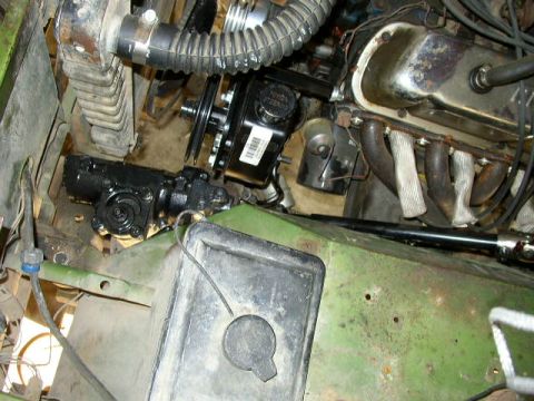 1995 Ford Bronco - Close-up view of engine and steering components in a green vehicle's engine bay.