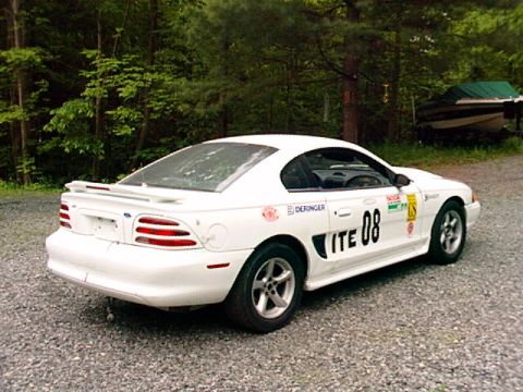 1995 Ford Mustang - White 1995 Ford Mustang race car with 'ITE 08' and 'DERINGER' decals, seen from a 3/4 front angle.