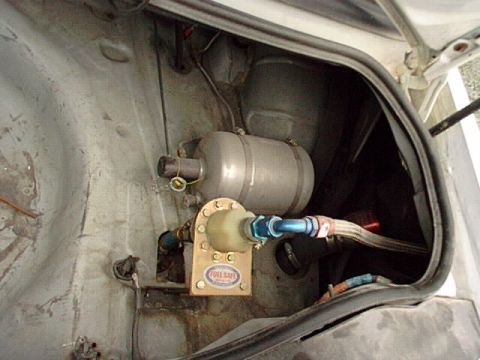 1995 Ford Mustang - Aftermarket fuel cell and pump assembly visible in the trunk of a car.