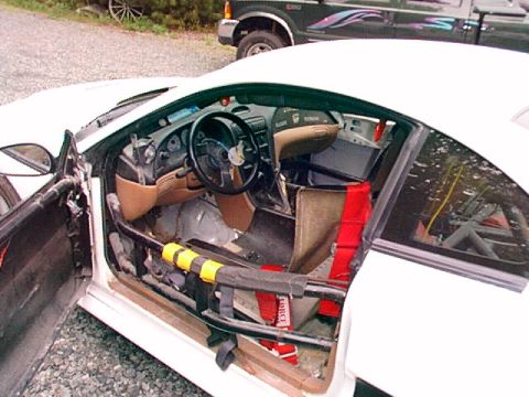 1995 Ford Mustang - Interior view of a white 1995 Ford Mustang race car, showing its custom racing modifications and safety equipment.