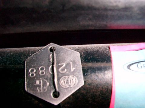 1995 Ford Mustang - A hexagonal metal tag with stamped numbers 88 and 1208 is attached to a dark surface.