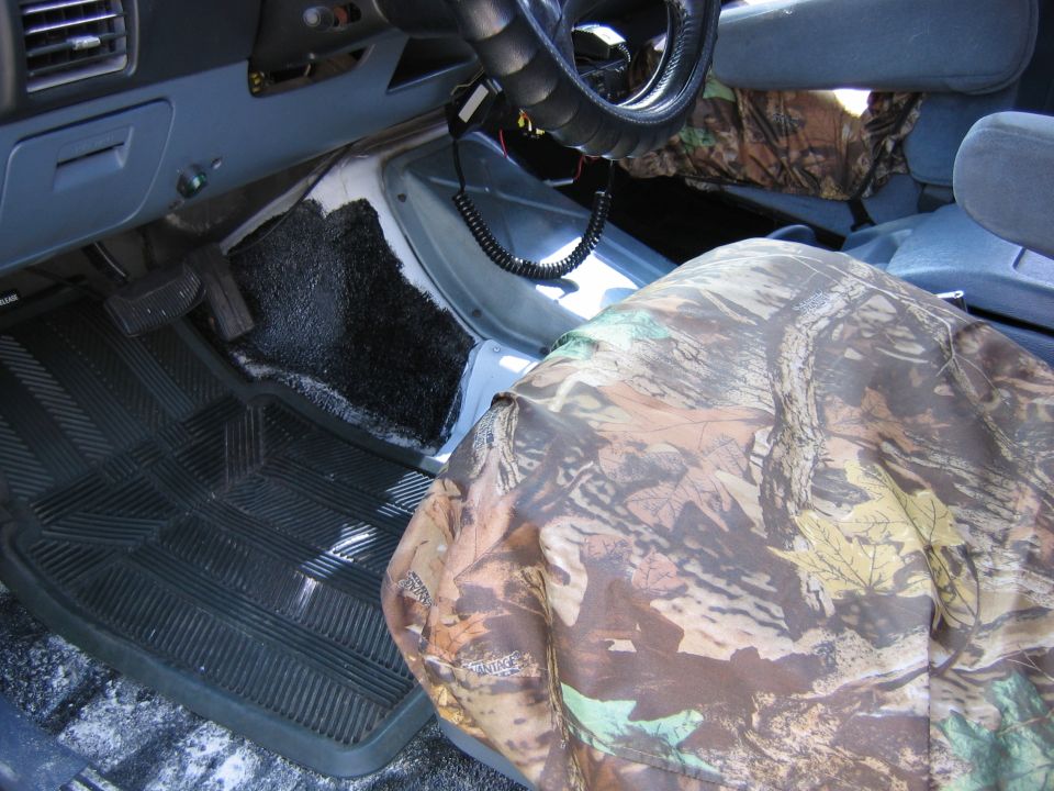 Truck interior with camo seat cover, gray dash and black rubber floor mat
