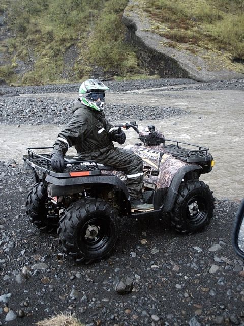 1996 Ford Bronco - Rider on an ATV gives a thumbs-up while stopped near a riverbed.