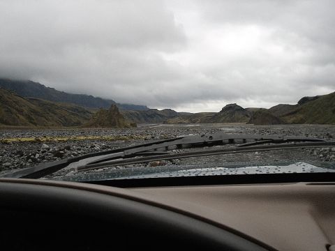 1996 Ford Bronco - View from inside a vehicle driving through a rocky, mountainous terrain on an overcast day.
