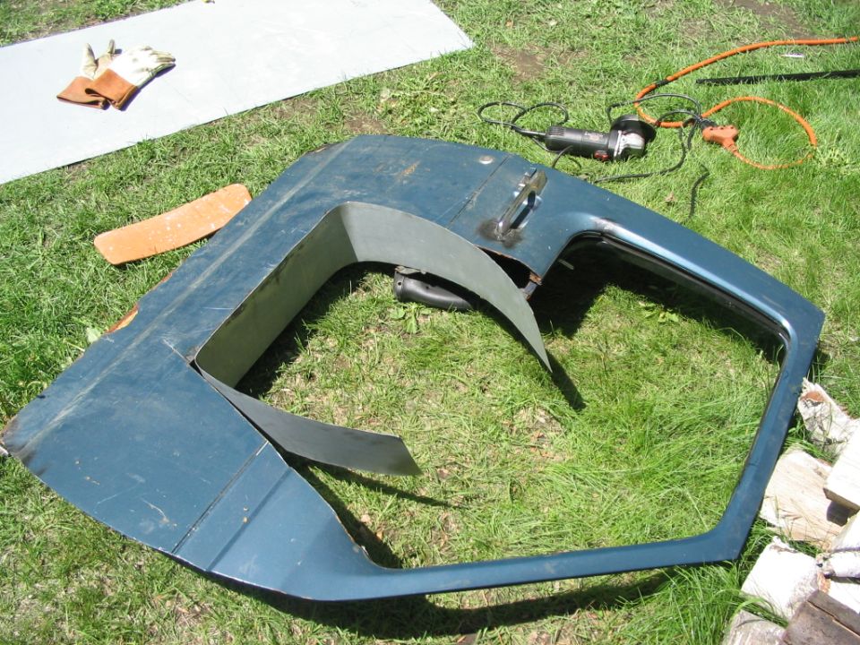 Blue truck door cut down into a half door on grass beside an angle grinder