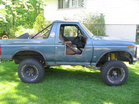 1986 Ford Bronco - This modified 1986 Ford Bronco features a custom roll cage and half doors, ready for off-road adventures.