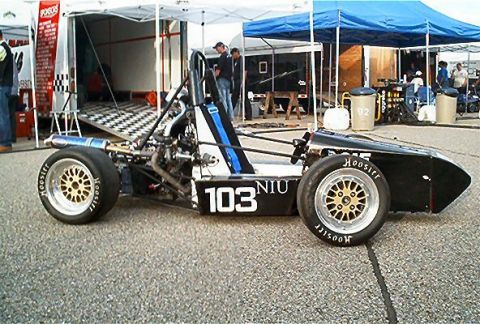 1985 Ford LTD Crown Victoria - A single-seat open-wheel Formula SAE race car shown in side profile, painted black with blue and white accents and marked '103 NIU'. It sit…