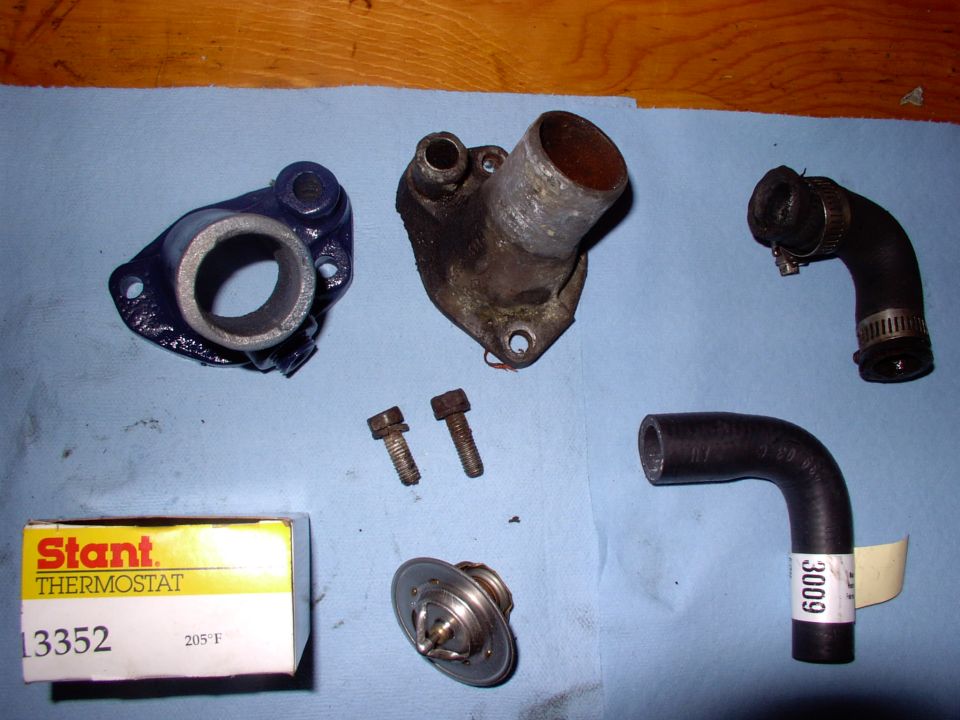 My T-stat housing was so corroded the hose wouldn't seal. New painted off-shore unit and bypass hose. Note the shorter bolt. I cut it to make life a lot easier, though I leave the 205 T-stat in all year.