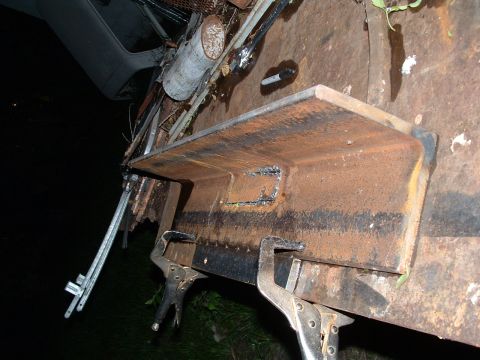 1979 Ford Bronco - Rusty metal bracket held by welding clamps, likely part of a custom fabrication project.