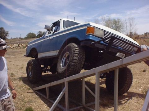 1988 Ford Bronco - A lifted 1987 Ford Bronco is positioned on a metal ramp during an off-road event.