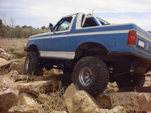 1988 Ford Bronco - This lifted 1987 Ford Bronco is shown off-roading over a rocky landscape.