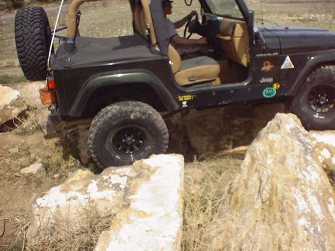 1988 Ford Bronco - Jeep Wrangler navigating a rocky off-road course.