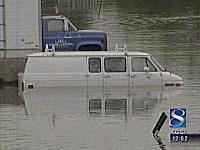 1998 Mercury Sable - Two vehicles are submerged in floodwaters, with only the upper portions visible.