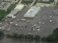 1998 Mercury Sable - Many vehicles are submerged in floodwaters in a large parking lot.