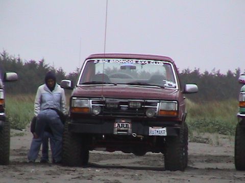 1994 Ford Explorer - A maroon Ford Bronco with off-road tires and an ARB bumper is parked on a sandy area.