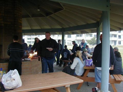 1994 Ford Explorer - A group of people are enjoying a barbecue under a covered pavilion, with apartment buildings visible in the background.