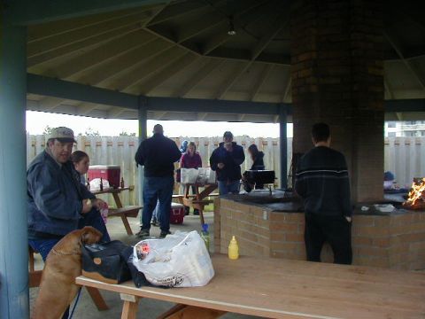 1994 Ford Explorer - A group of people are enjoying a gathering at a picnic area with a large brick grill.