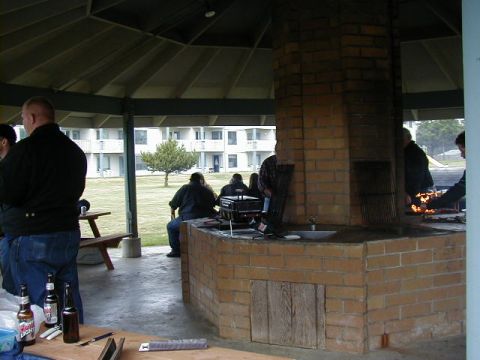 1994 Ford Explorer - A group of people are enjoying a gathering at an outdoor picnic shelter with a large brick barbecue pit.
