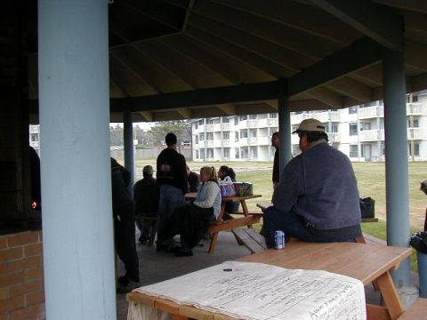 1994 Ford Explorer - A group of people are seen under a covered pavilion with picnic tables, with apartment buildings in the background.