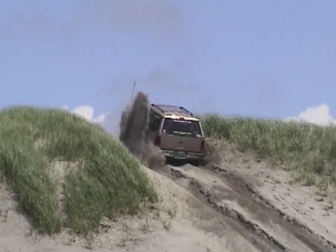 1994 Ford Explorer - A 1994 Ford Explorer navigates a sandy dune, sending up a plume of dust.