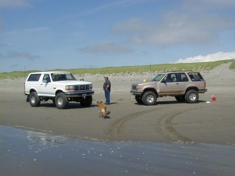 1994 Ford Explorer - A lifted 1994 Ford Explorer is parked on the sand next to a white Ford Bronco.