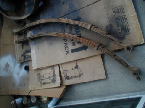 1988 Ford Bronco - Leaf springs are shown on top of cardboard boxes, indicating they are parts for a vehicle.