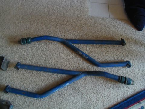 1988 Ford Bronco - Two blue metal bars with green ends, each inscribed with 'James Duff', lie on a carpeted surface.