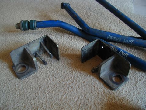 1988 Ford Bronco - Two metal brackets and blue suspension bars with "James Duff" branding are laid out on a carpeted surface.