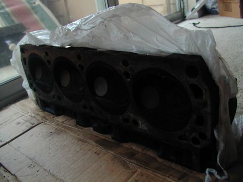 1988 Ford Bronco - Engine block part shown on cardboard, with plastic covering.