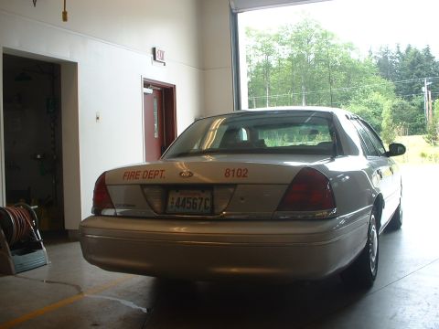 1999 Ford Crown Victoria - Rear view of a Ford Crown Victoria, marked for the fire department, parked inside a garage.