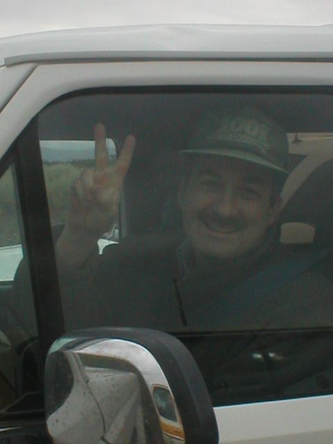 1978 Ford Bronco - Man in a vehicle gives a peace sign while wearing a hat with '2007' on it.