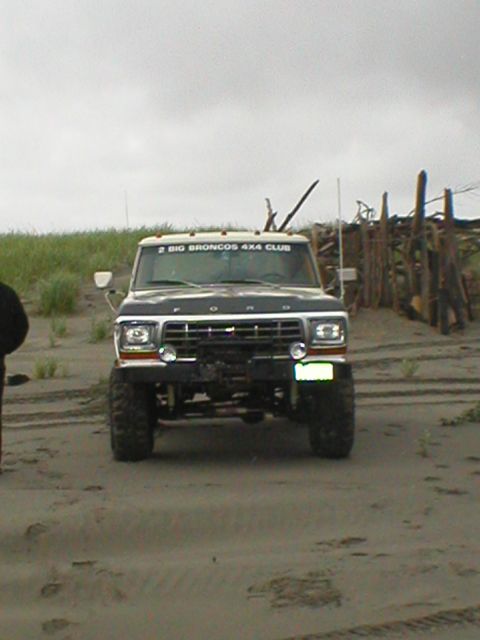 1978 Ford Bronco - A 1978 Ford Bronco is parked on a sandy beach under an overcast sky.