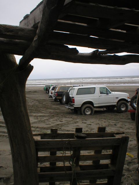 1978 Ford Bronco - Several SUVs are parked on a sandy beach, with the ocean in the background.