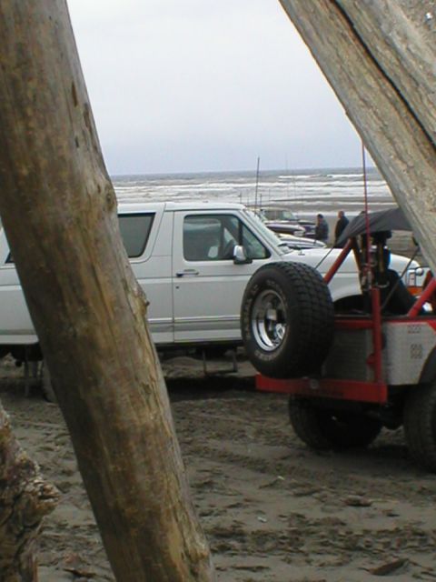 1978 Ford Bronco - Two vehicles are parked on a sandy beach with the ocean in the background.