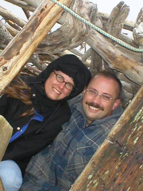 1978 Ford Bronco - A couple smiles for the camera while within a rustic driftwood shelter on the coast.