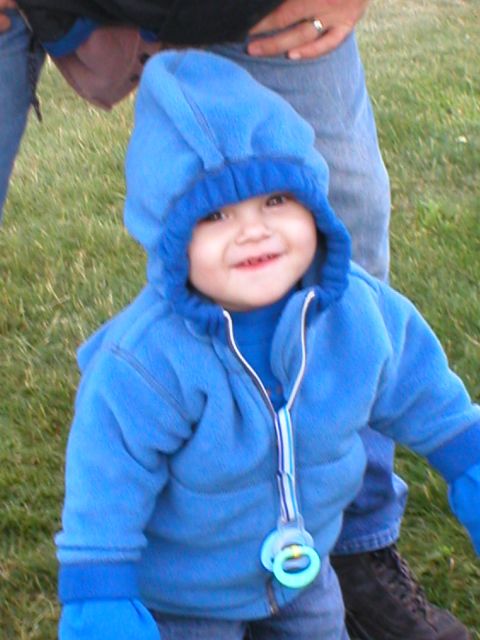 1978 Ford Bronco - A smiling baby in a blue hooded jacket and mittens is seen outdoors on a grassy area.