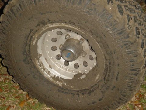 1989 Ford Bronco - Close-up of a muddy tire and wheel, suggesting off-road use.