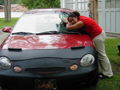 1997 Ford Taurus - Woman rests her head on the hood of a 1997 Ford Taurus covered with a car bra.