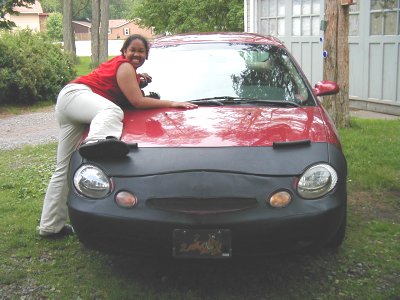 1997 Ford Taurus - A woman poses on the hood of a red car with a black car bra.