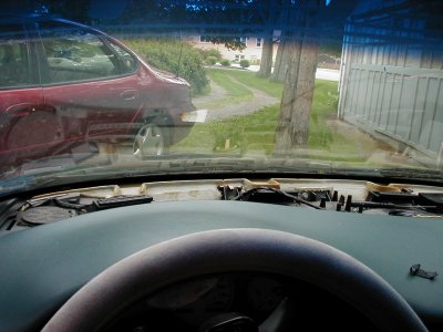 1997 Ford Taurus - View from inside a red 1997 Ford Taurus, showing the dashboard in a state of disassembly.