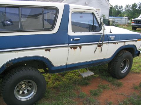 1978 Ford Bronco - Side view of a 1978 Ford Bronco showing its two-tone paint and signs of rust.