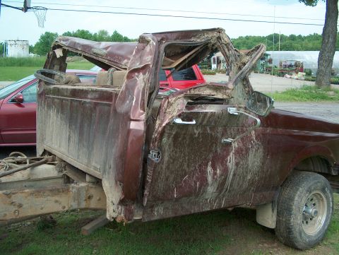 1990 Ford F-150 - This heavily damaged 1990 Ford F-150 pickup truck shows extensive cab and roof damage, indicating a severe impact.